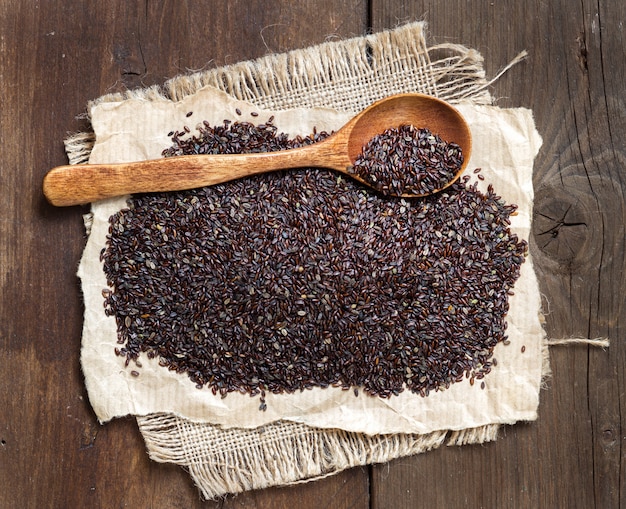 Psyllium seeds with a spoon on a wooden table top view