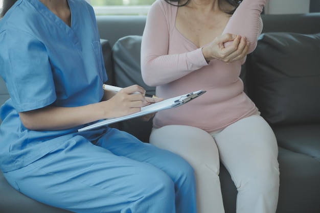 PTSD Mental health concept Psychologist sitting and touch hand young depressed asian man for encouragement near window with low light environmentSelective focus