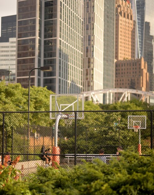 Photo public basketball court with modern skyscrapers on background