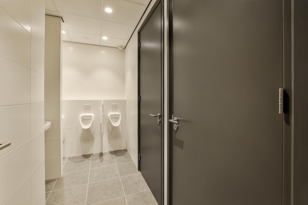 Foto un bagno pubblico con due orinatoi e una porta