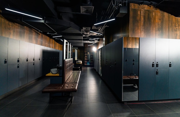 Public changing room interior with leather benches and lockers\
in locker room in luxury gym centre sport and recreation\
concept