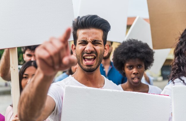 Public demonstration on the street against social problems and human rights. Group of multiethnic people making public protest