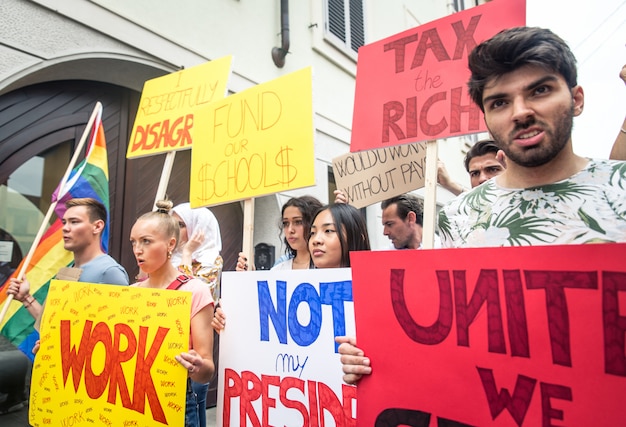 Public demonstration on the street against social problems and human rights. Group of multiethnic people making public protest