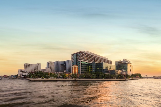 Photo public hospital, faculty of medicine siriraj hospital at twilight time in the chao phraya river, bangkok, thailand