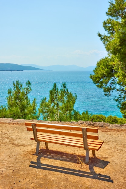 晴れた夏の日にエギナ島の海の海岸にベンチのある公共公園、エギナ島、ギリシャ-風景