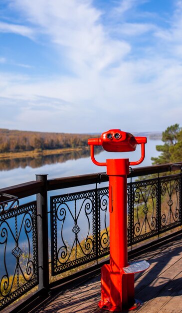 Public stationary binoculars on the banks of the river in summer