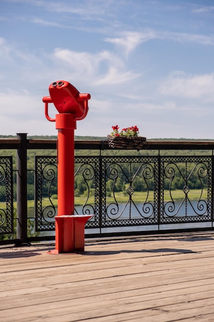 Public stationary binoculars on the banks of the river in summer