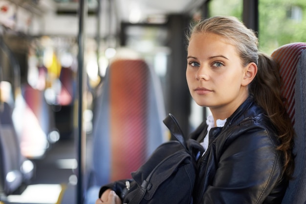 I mezzi pubblici la portano dove vuole andare una ragazza seduta sull'autobus mentre torna a casa da scuola