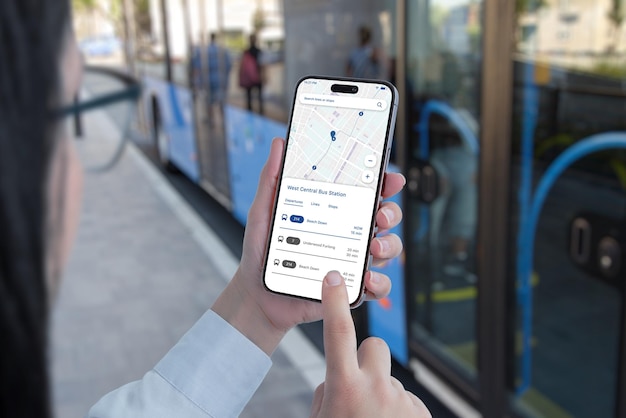 Public transportation app on smartphone in woman hands concept Bus on station in background