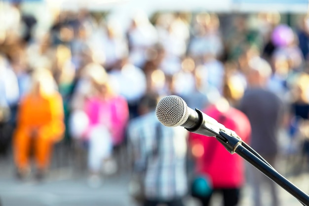 Foto microfono di pubblicità o di un evento mediatico a fuoco contro persone sfocate sullo sfondo