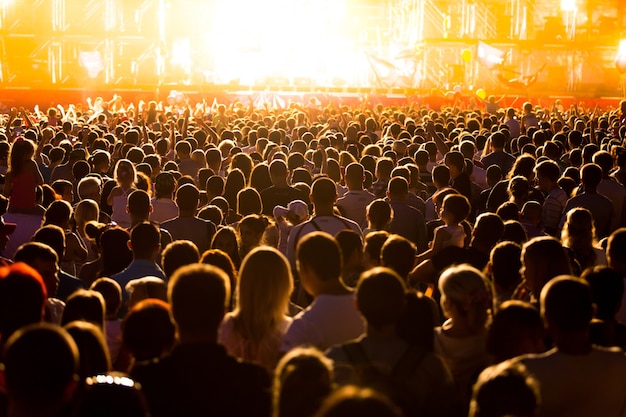 Publiek op een muziekfestival en lichten die van boven het podium naar beneden stromen. Zachte focus,