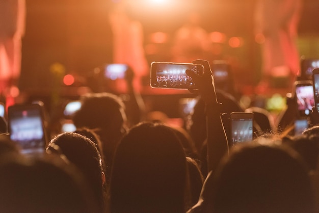 Foto publikum fotografeert met een smartphone tijdens een muziekconcert