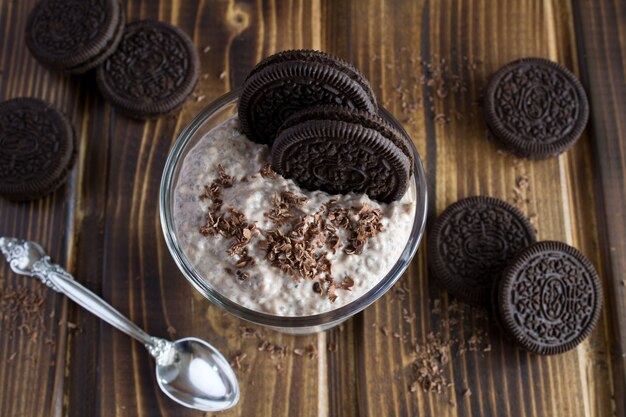 Pudding met chia en chocoladekoekje op het bruine houten oppervlak. Bovenaanzicht.