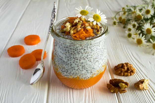 Pudding met chia, wortel en walnoten op de witte houten achtergrond