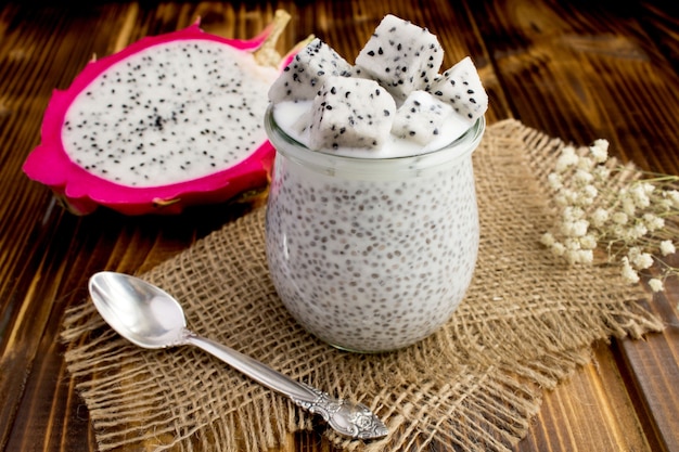 Pudding with chia and dragon fruit in the glass jar on the rustic wooden