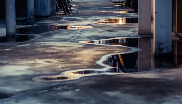 Puddle water reflection on ground. Parking lot with abstract water puddle reflection. Urban life concept idea.