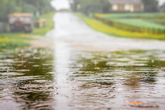 Pozza con acqua sulla strada durante la doccia. pioggia forte durante la giornata estiva