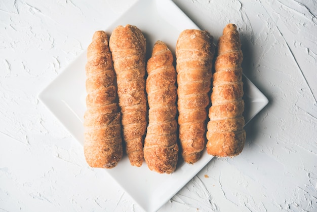 Puff cream rolls or Pastry served over moody background. selective focus