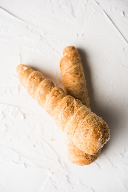 Puff cream rolls or Pastry served over moody background. selective focus