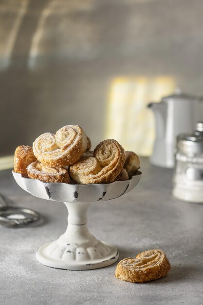 Puff pastry cookies palmier or elephant ears crunchy pastry heart shaped in white dish breakfast concept
