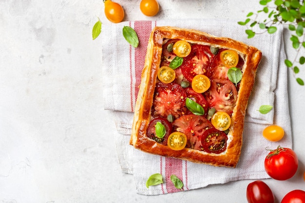 Foto tortino di pasta sfoglia con pomodorini e basilico