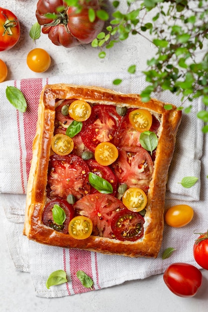 Foto tortino di pasta sfoglia con pomodorini e basilico