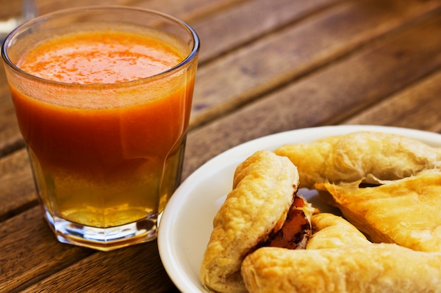 Puff pastry and pumpkin juice on wooden table