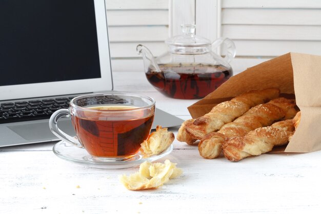 Puff pastry sticks with sesame seeds in a paper bag with milk