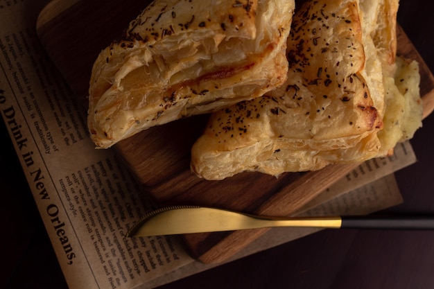 Puff pastry on wooden board with knife on the side top view