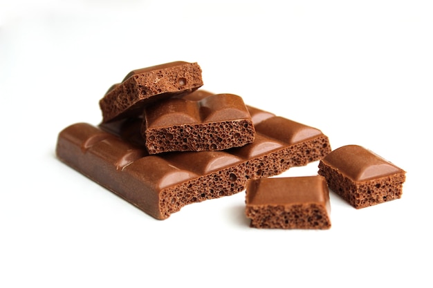 Puffed milk chocolate slices stacked on top of each other on a white plate. Delicious, sweet, high-calorie dessert for a snack.