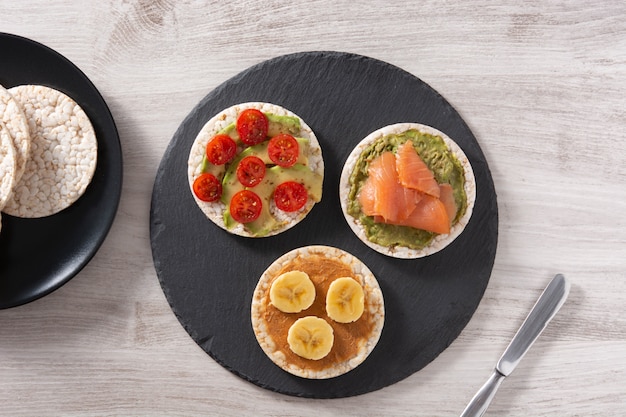 Puffed rice cake with banana and peanut butter on wooden table