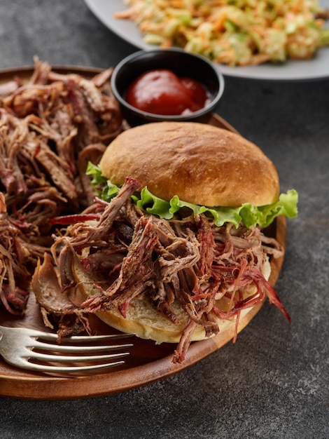 Pulled pork burger Burger with pork meat on a wooden board