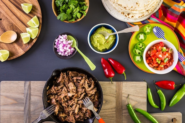 Pulled pork carnitas met pico de gallo op een bloemtortilla.