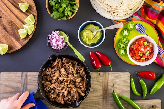 Pulled pork carnitas met pico de gallo op een bloemtortilla.