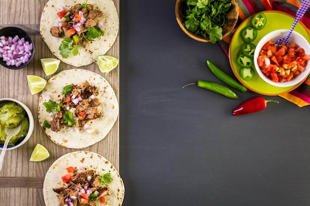 Pulled pork carnitas with pico de gallo on a flour tortilla.