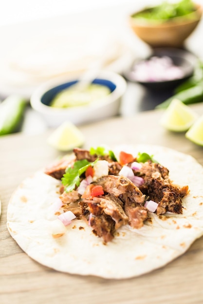 Pulled pork carnitas with pico de gallo on a flour tortilla.