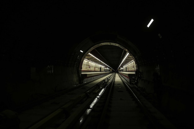 Вытягивание рельсов внутри темного туннеля для запуска метро