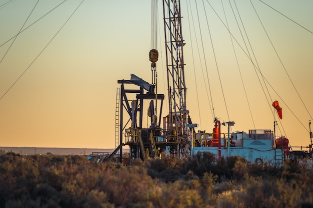 Pulling team fixing oil pump at sunset