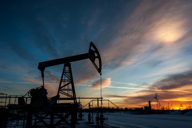 Photo pump jack at sunset sky background. extraction of oil. petroleum concept.