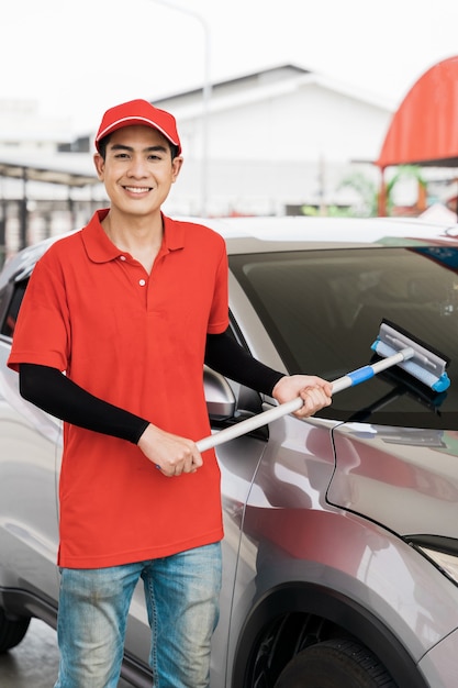 Photo pump worker washing car window at gas station