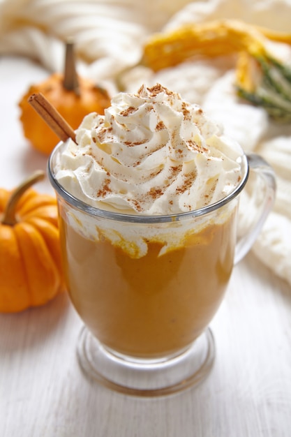 Foto latte di zucca con panna montata e spezie