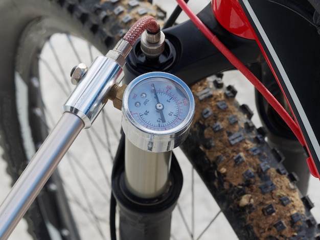 Foto pompaggio della parte anteriore, ammortizzatore olio-aria della bicicletta mediante una pompa manuale specializzata.