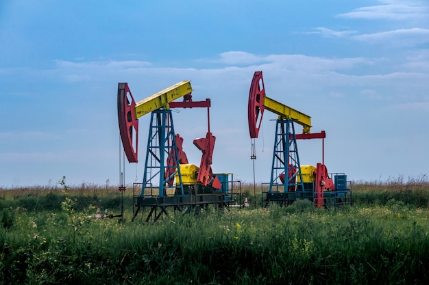 Pumpjacks piston pumps operating at an oil well in field outdoors