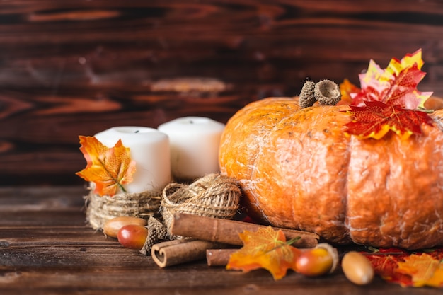 Pumpkin, acorns, yellow leaves, cinnamon on a dark background