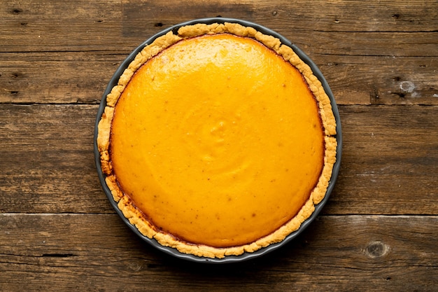 Pumpkin american pie on a wooden background top view copy space