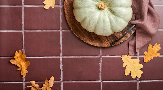 Pumpkin Autumn food background with cinnamon nuts and seasonal spices on old ceramic tiles background Cooking pumpkin or apple pie and cookies for Thanksgiving and autumn holidays Top view