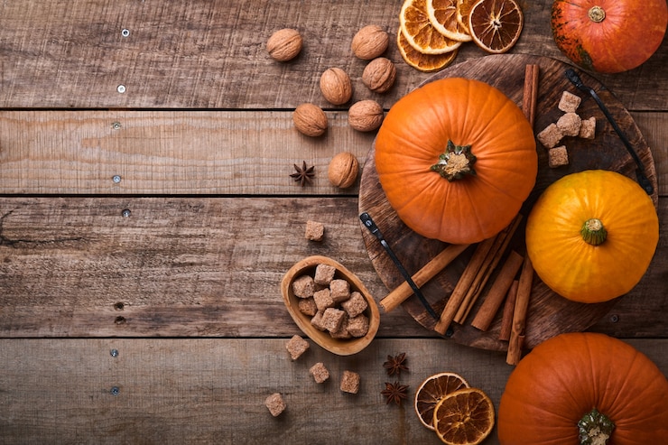 Photo pumpkin. autumn food background with cinnamon, nuts and seasonal spices on rustic background. cooking pumpkin or apple pie and cookies for thanksgiving and autumn holidays. top view with copy space.