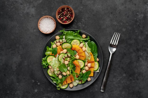 pumpkin, avocado, cucumber, chickpeas, salad on a plate. Tasty healthy salad