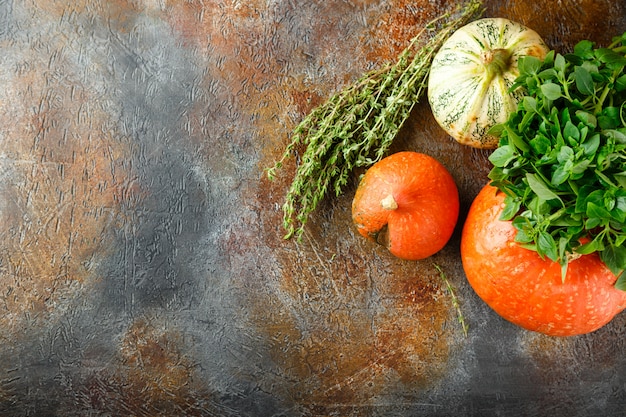 Pumpkin, basil and thyme on a rusty table