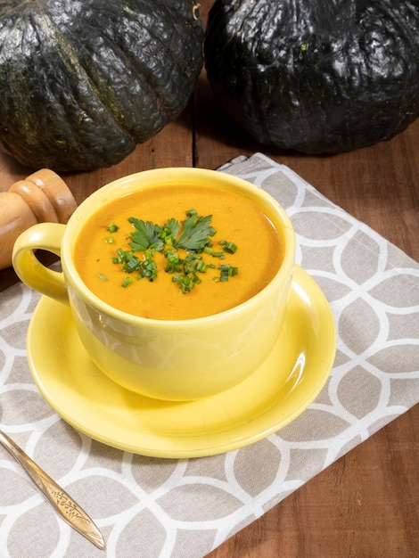 Pumpkin broth on wooden background.